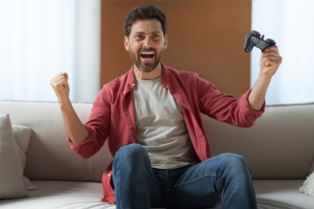 Homme qui joue aux jeux vidéo sur un canapé