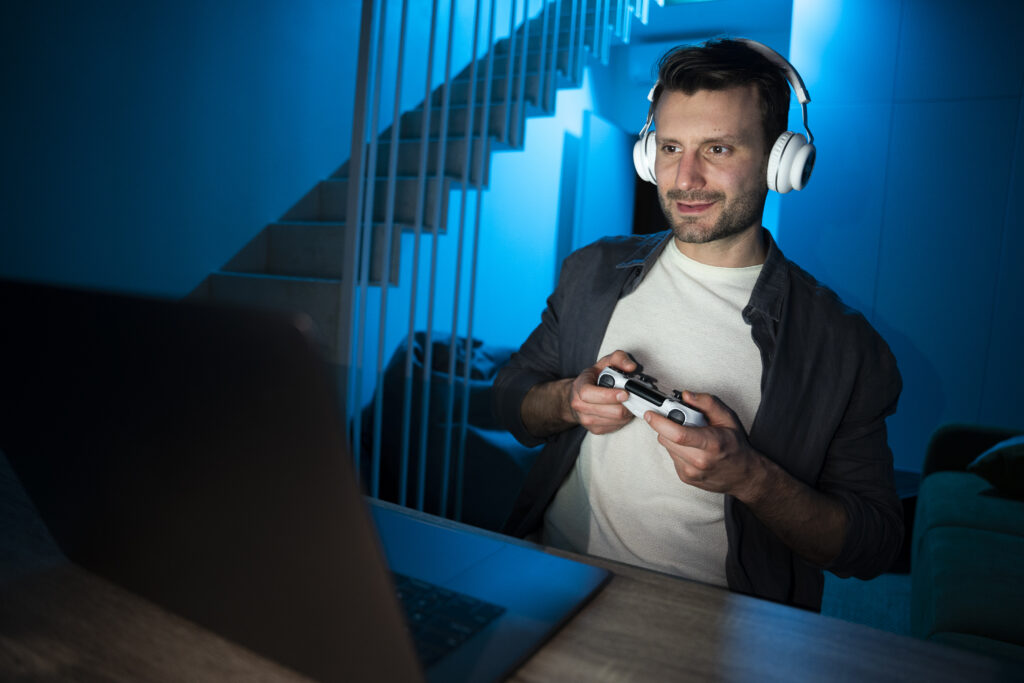 Jeune homme adulte qui joue aux jeux vidéo sur son ordinateur