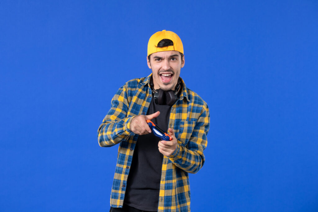 Jeune homme avec une manette de jeux vidéo sur fond bleu